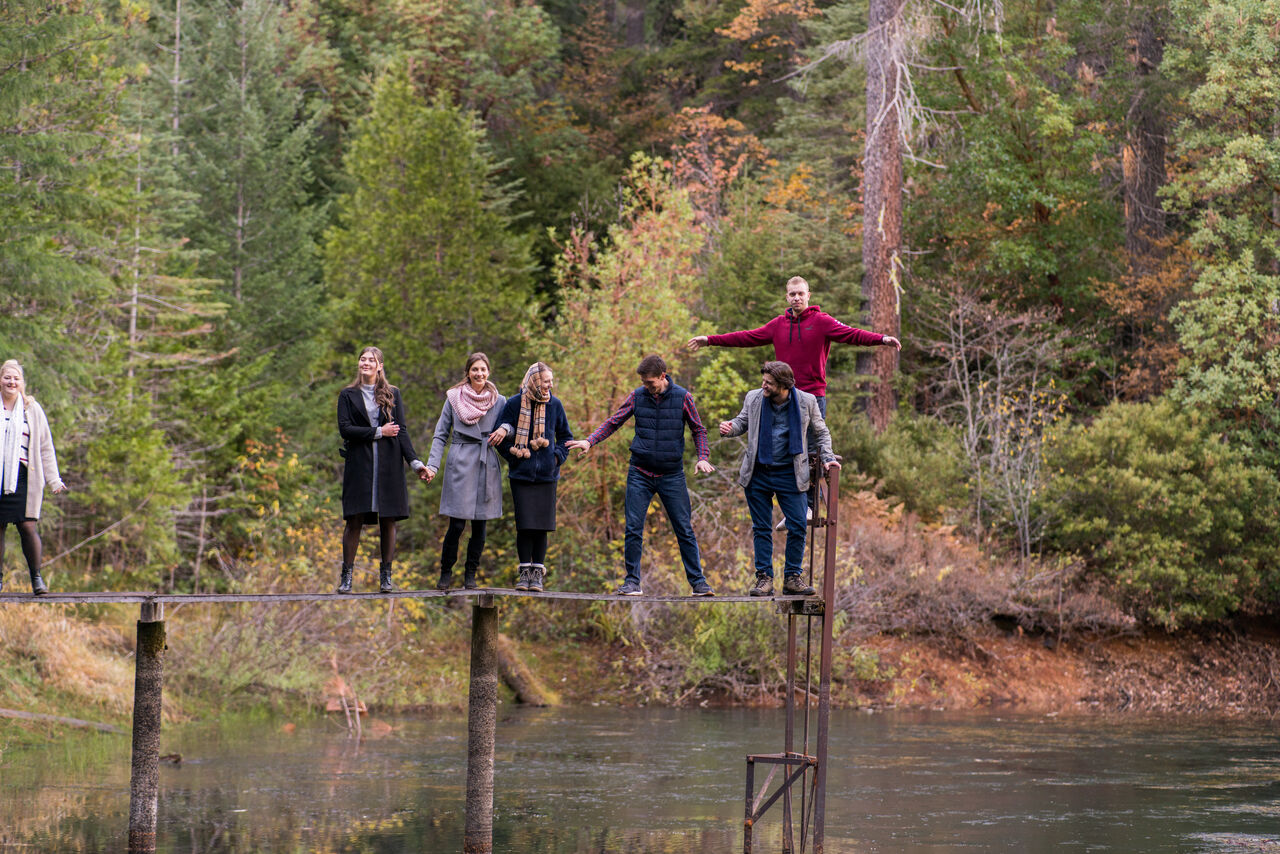 A group balancing together on a bridge over the pond